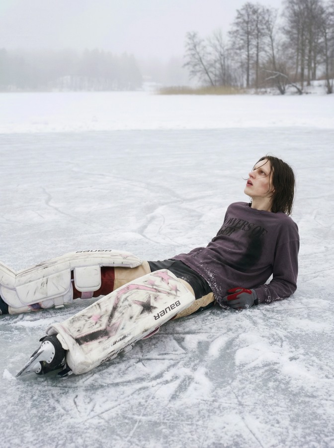 AI-created goalkeeper reclining on a frozen lake, wearing a purple shirt and white pads