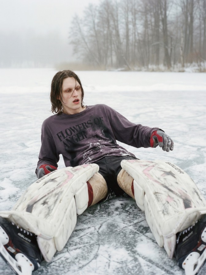 AI-created goalkeeper sitting on the ice with white pads spread in front of him