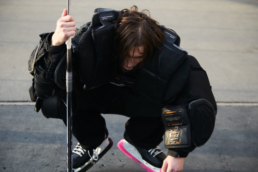 Marks crouched with a hockey stick held upright