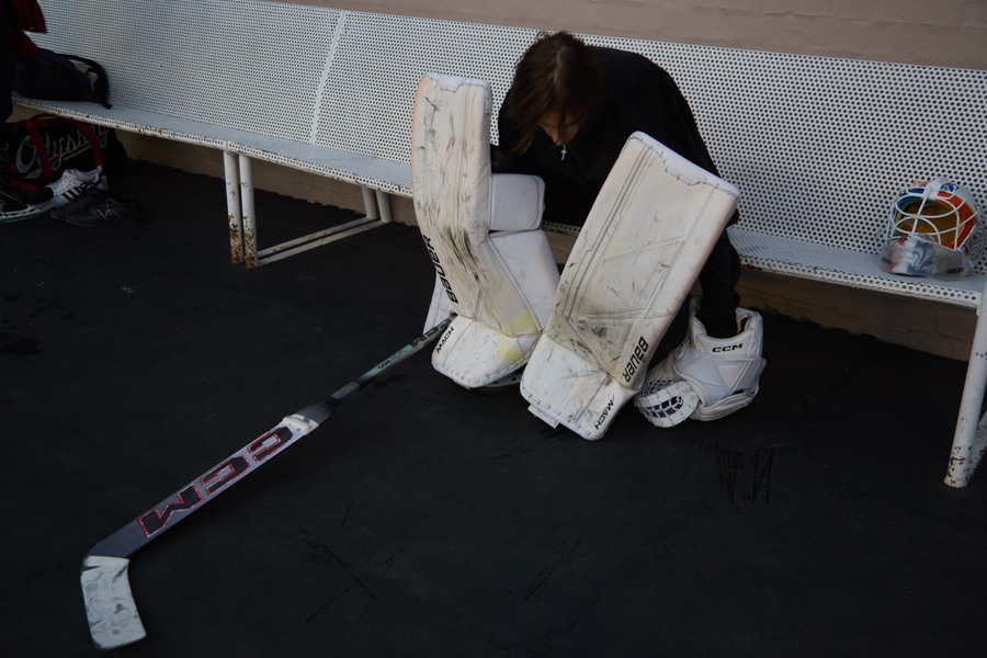 Marks seated with white goalkeeper pads in front of him beside the rink